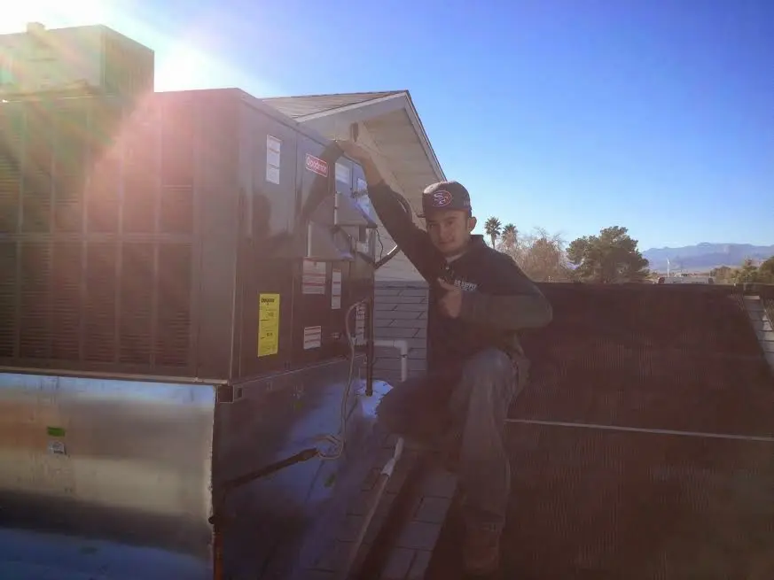 HVAC technician performing Boiler Repair on a rooftop unit in Ladue